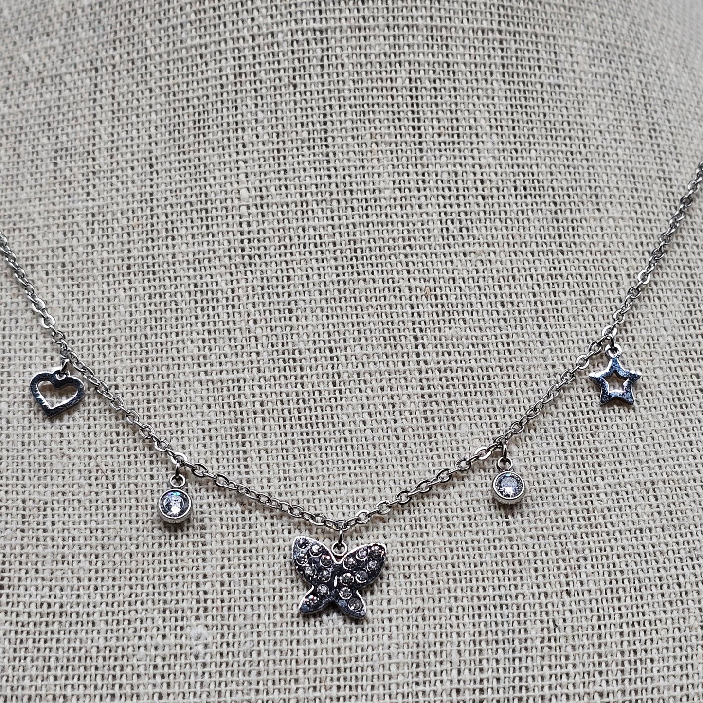 Collier argenté en acier – maille forçat fine, pampilles papillon & strass