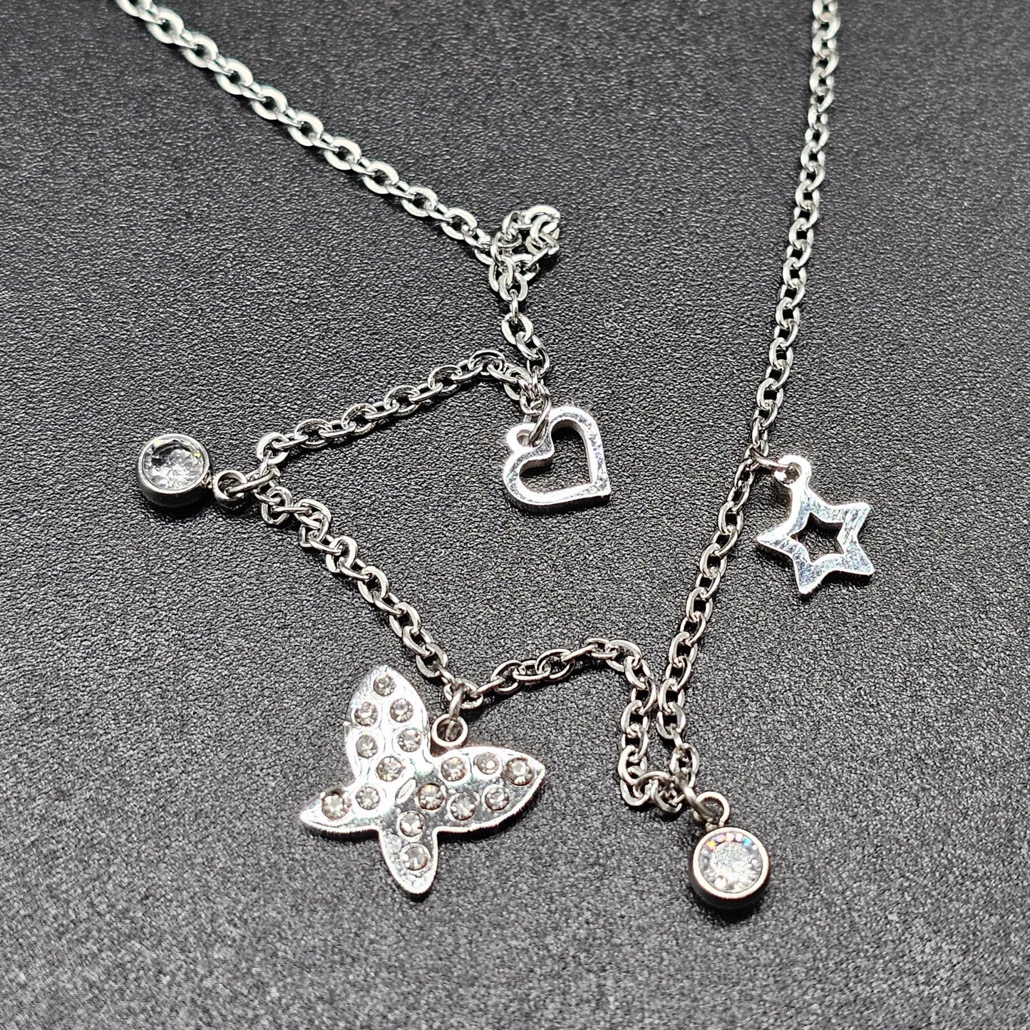 Collier argenté en acier – maille forçat fine, pampilles papillon & strass