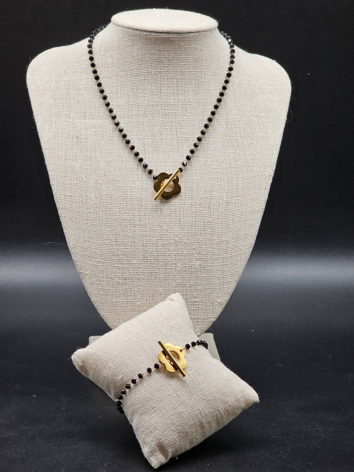 Gold stainless steel necklace with thin chain, black faceted beads and gold flower T-bar clasp