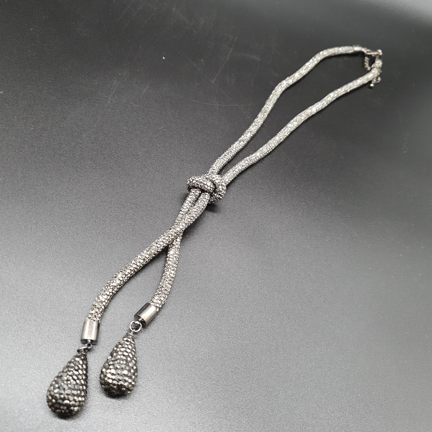 Collier sautoir chaîne maille tube rigide argentée effet strass nœud gouttes