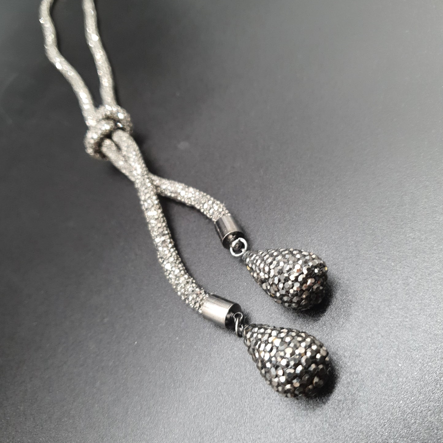 Collier sautoir chaîne maille tube rigide argentée effet strass nœud gouttes