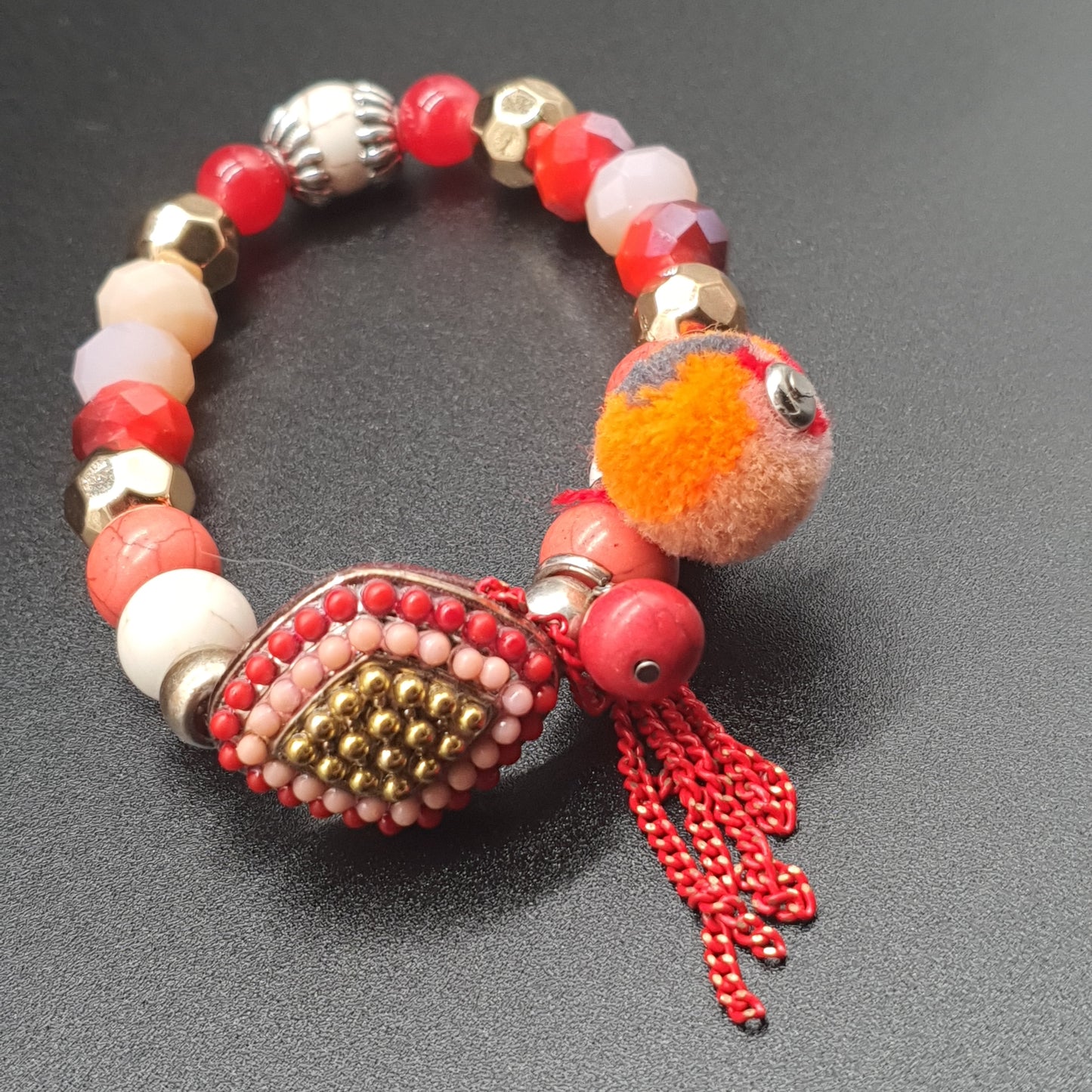 Bracelet élastique perles rouges dorées pompon tassel