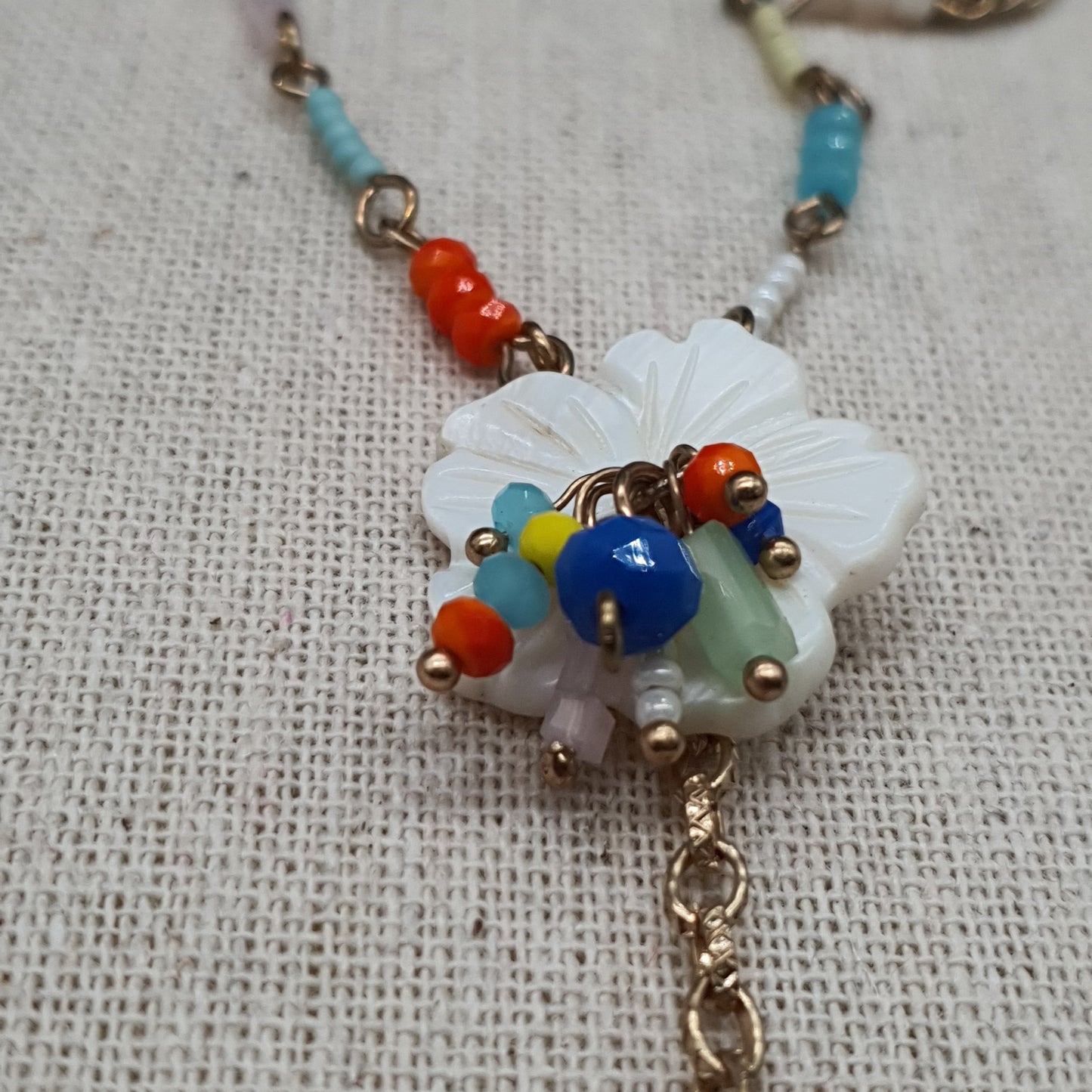 Collier sautoir double rang acier doré chaînes à billes maille gourmette perles fantaisie colorées pompon tassel pampille dorée pendentifs pierre reconstituée fleur en nacre chaînettes colorées