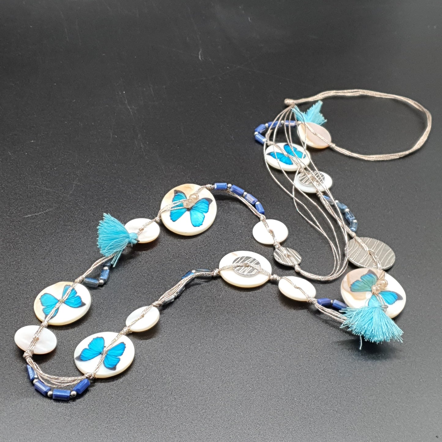Collier sautoir multi-fils bleu – Nacre, papillon argenté & pompons