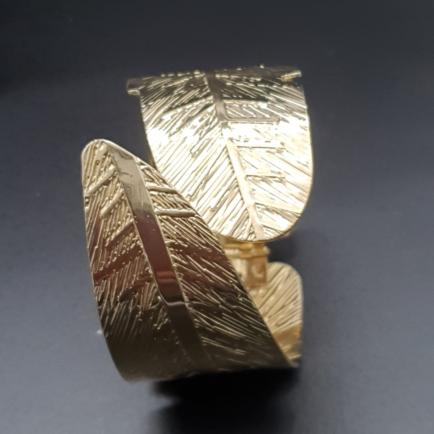 Bracelet manchette ouvrable acier doré ciselé plumes entrecroisées