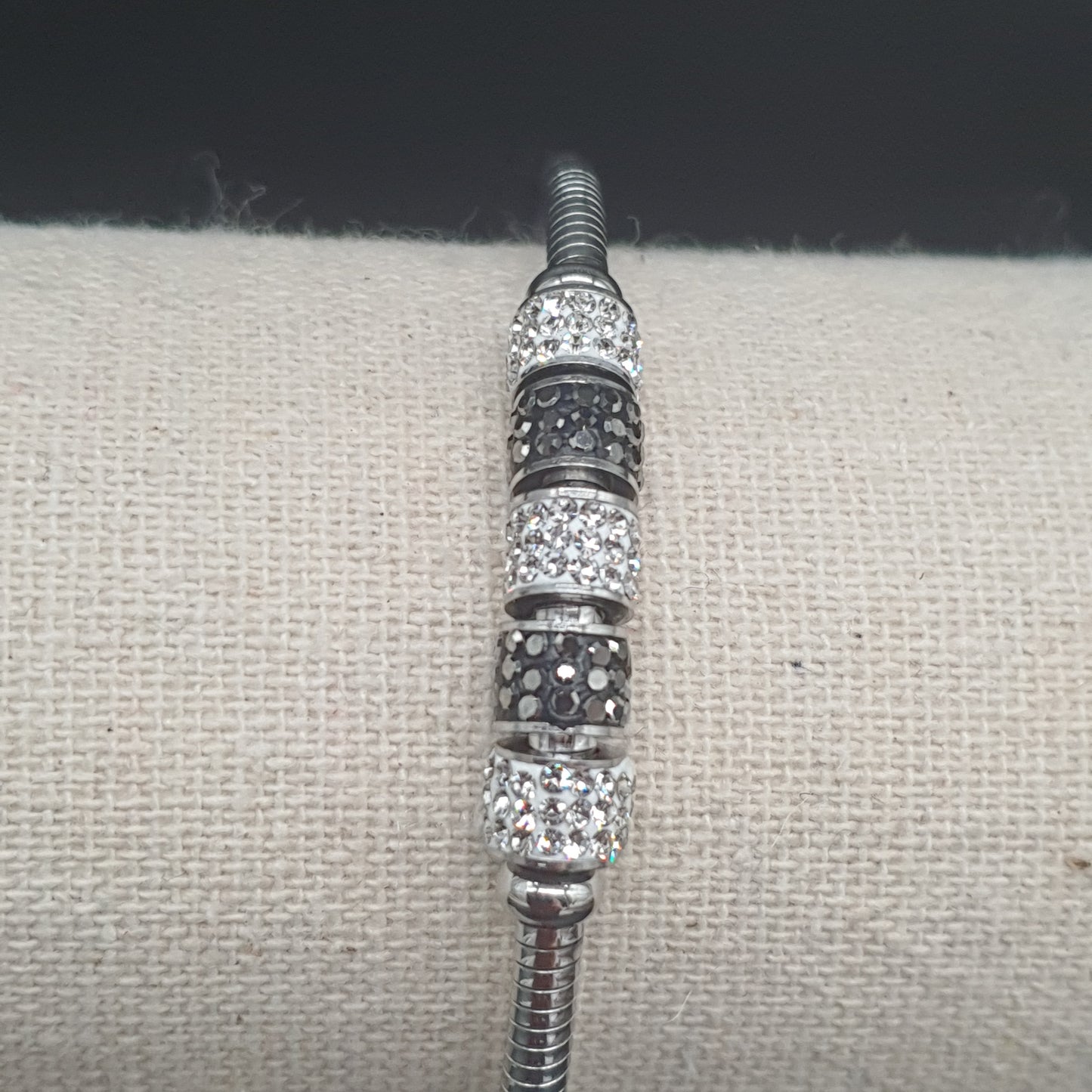 Bracelet aimanté maille oméga argentée tubes métal strass blancs éclats de cristal noirs