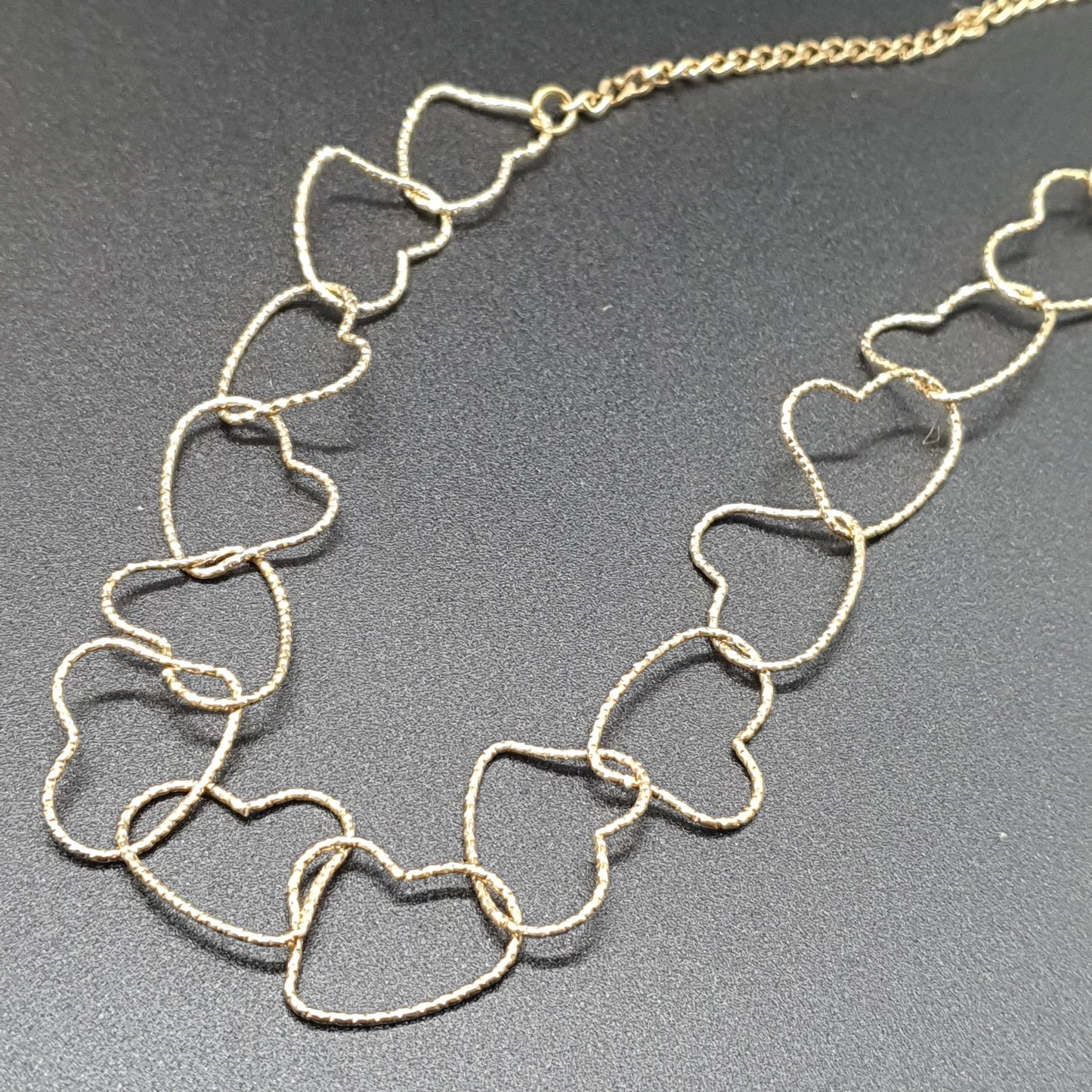 Gold-plated steel necklace, fine cable chain, intertwined hearts in gold-toned metal