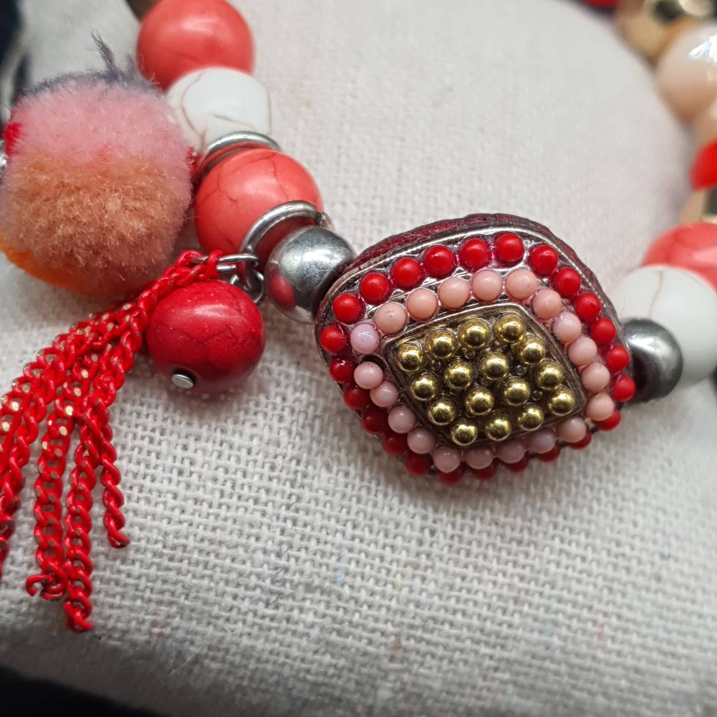 Bracelet élastique perles rouges dorées pompon tassel