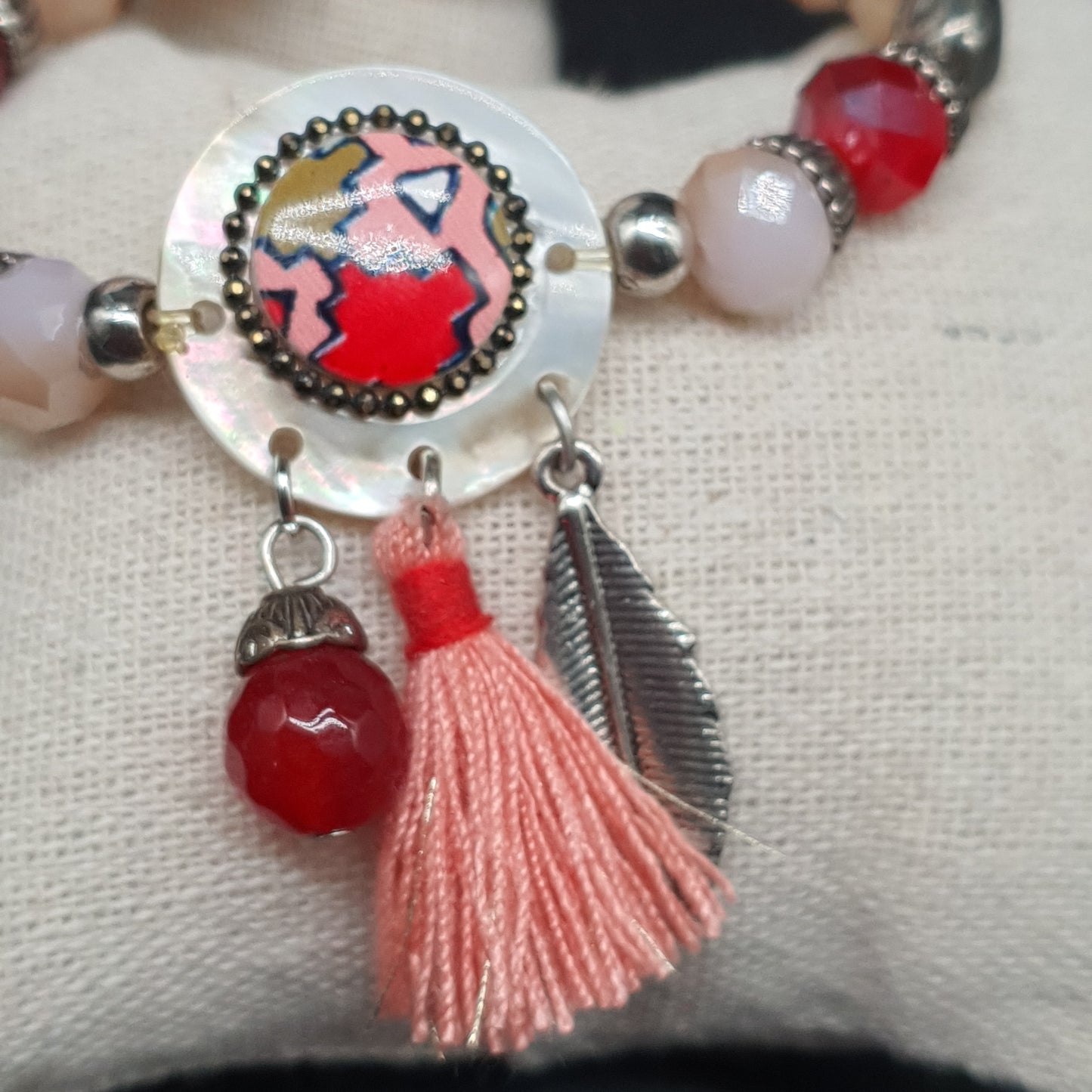 Bracelet élastique perles rouges et dorées orné d’une pièce nacre aztèque