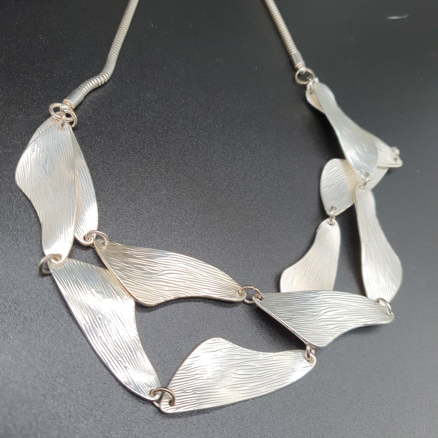 Collier double rang maille serpent pièces courbées métal argent brosséé