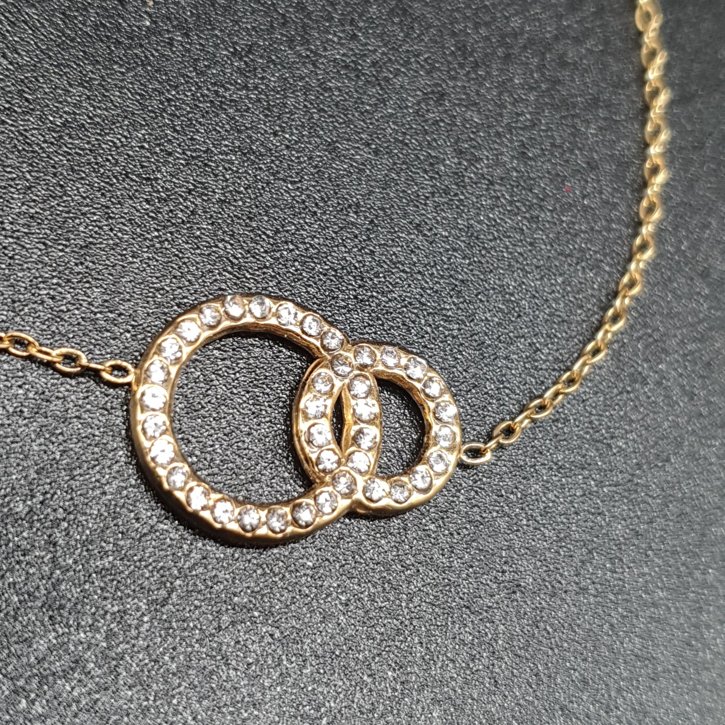 Fine gold-plated bracelet with two intertwined rings and crystals – Stainless steel