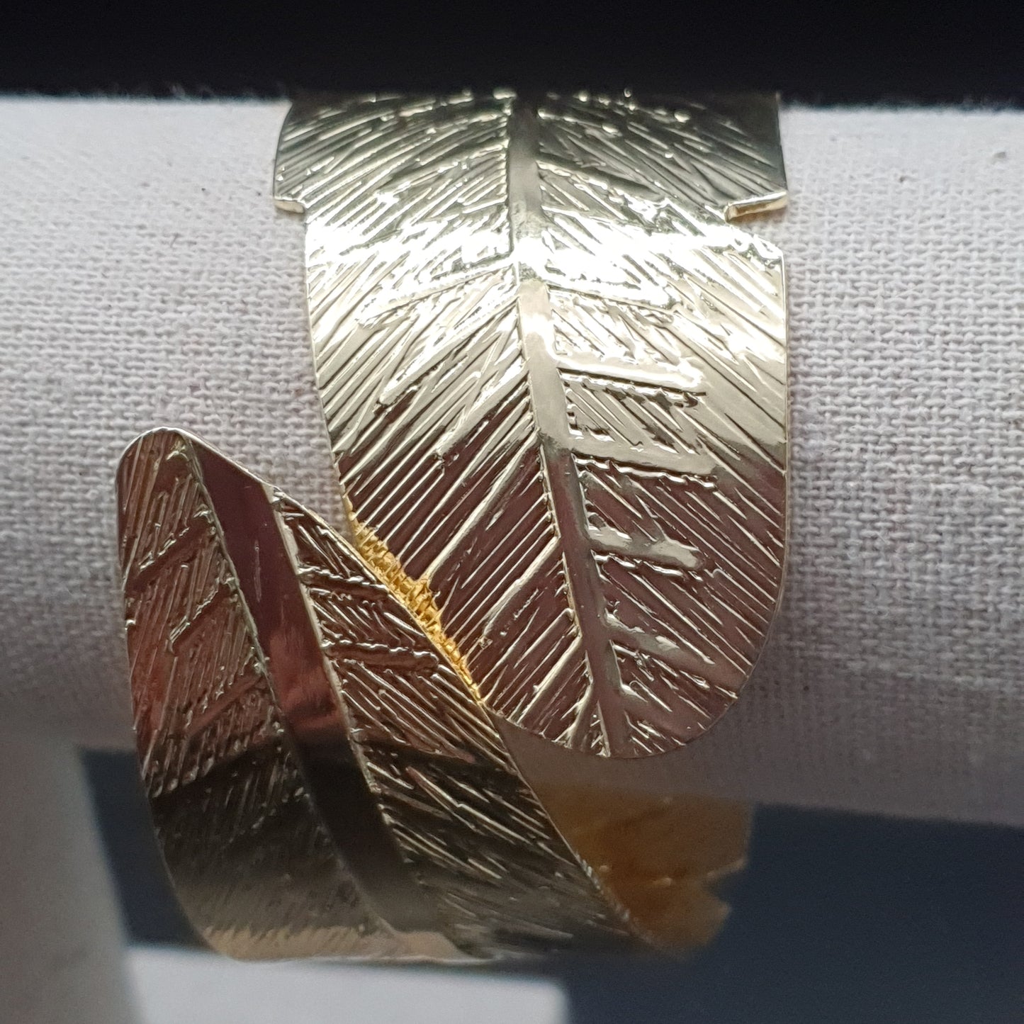 Gold-plated openwork hinged cuff bracelet with intertwined feathers