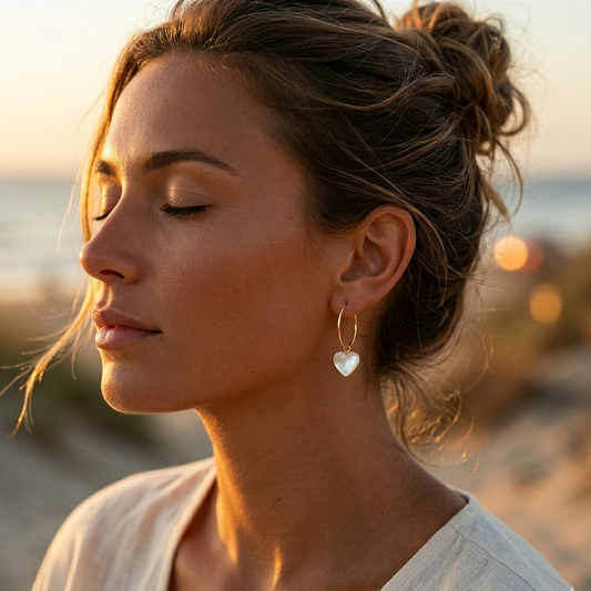 Gold hoop earrings with a mother-of-pearl heart charm, hypoallergenic stainless steel.