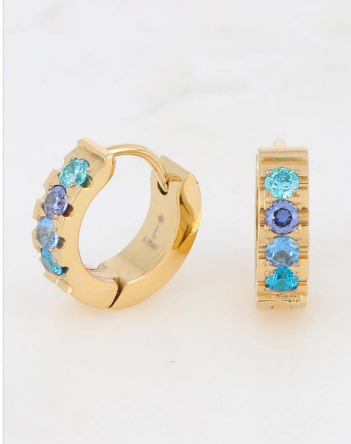 Boucles créoles dorées avec strass bleus sur présentoir – Bijoux Nice