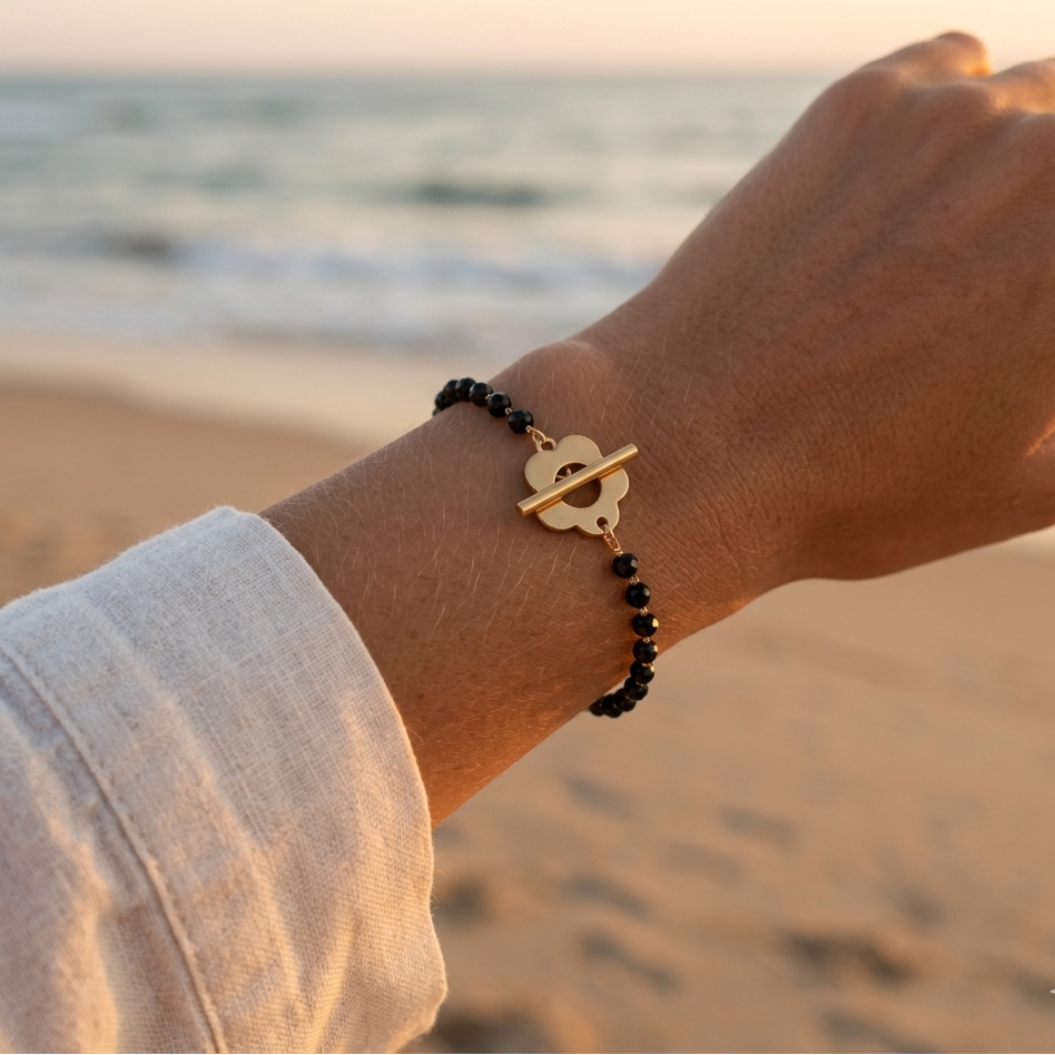 Fine gold-plated steel chain bracelet with faceted hematite beads – flower clasp