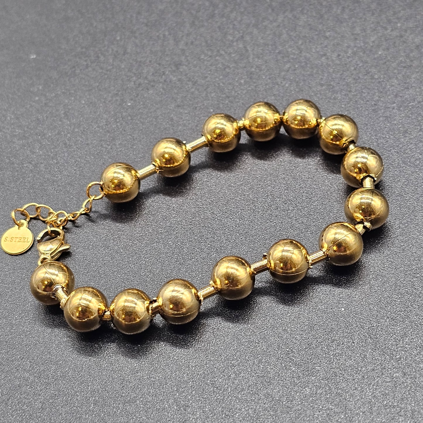 Bracelet doré en acier inoxydable avec perles rondes, bijou brillant et élégant à porter au quotidien.