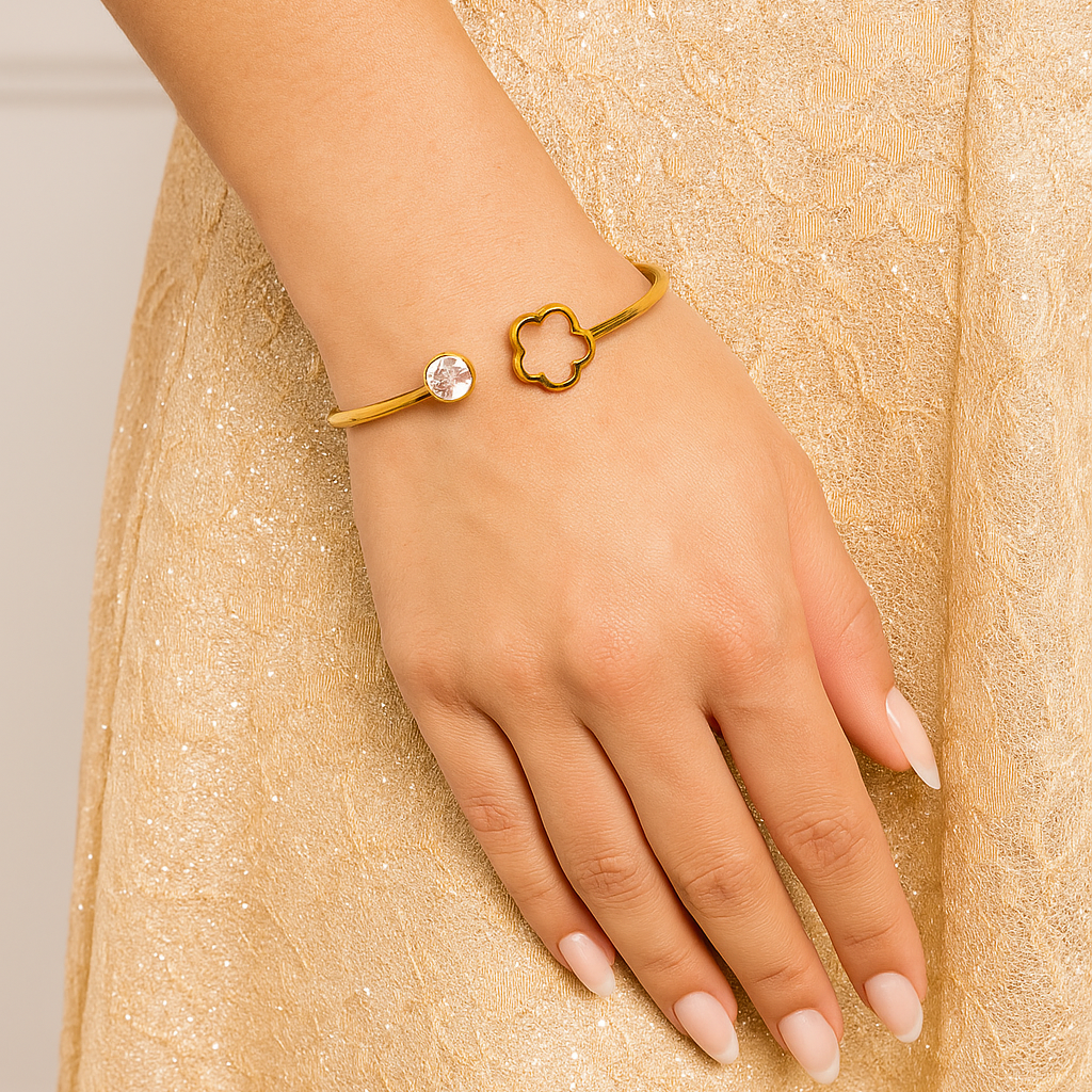 Bracelet jonc doré orné d’un trèfle et d’un strass brillant, bijou élégant porté sur model Bijoux Nice