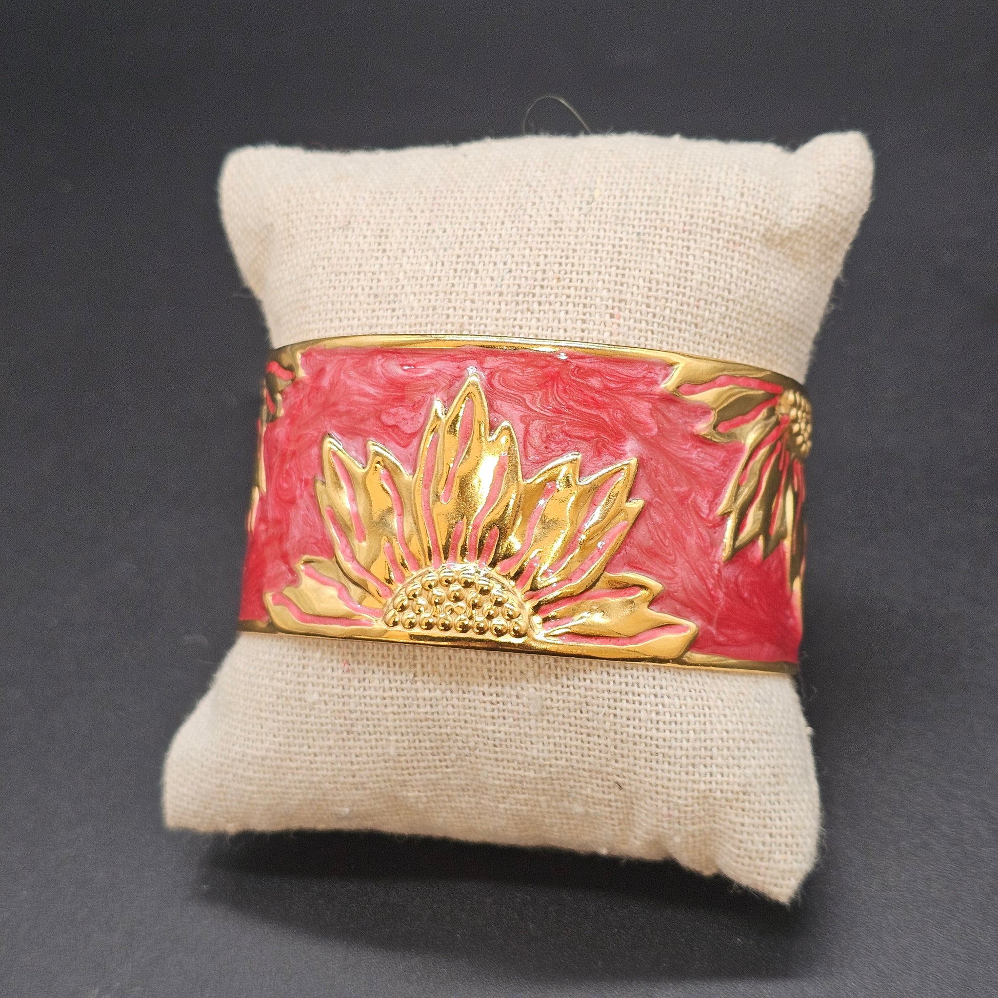 Bracelet manchette doré et rose sur coussin beige, décor soleil en relief – Bijoux Nice.