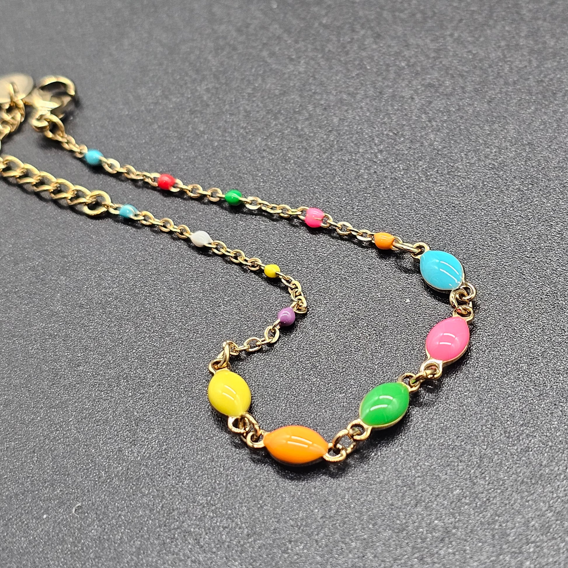 Bracelet fin doré orné de perles multicolores, bijou léger et moderne pour femme.