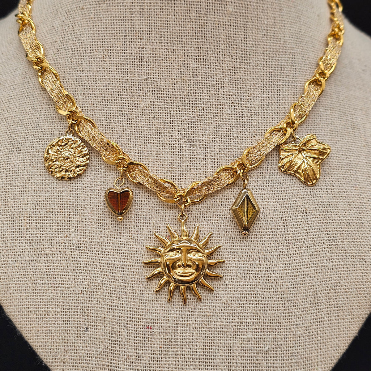 Détail rapproché du collier doré, texture du métal et reflets brillants.