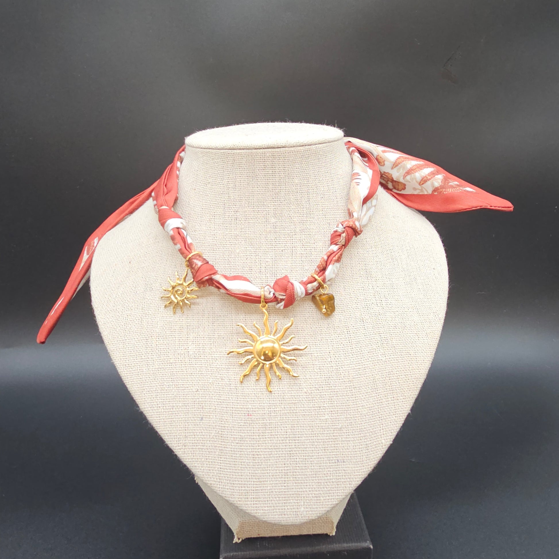 Vue principale sur présentoir, collier bien centré, fond neutre.