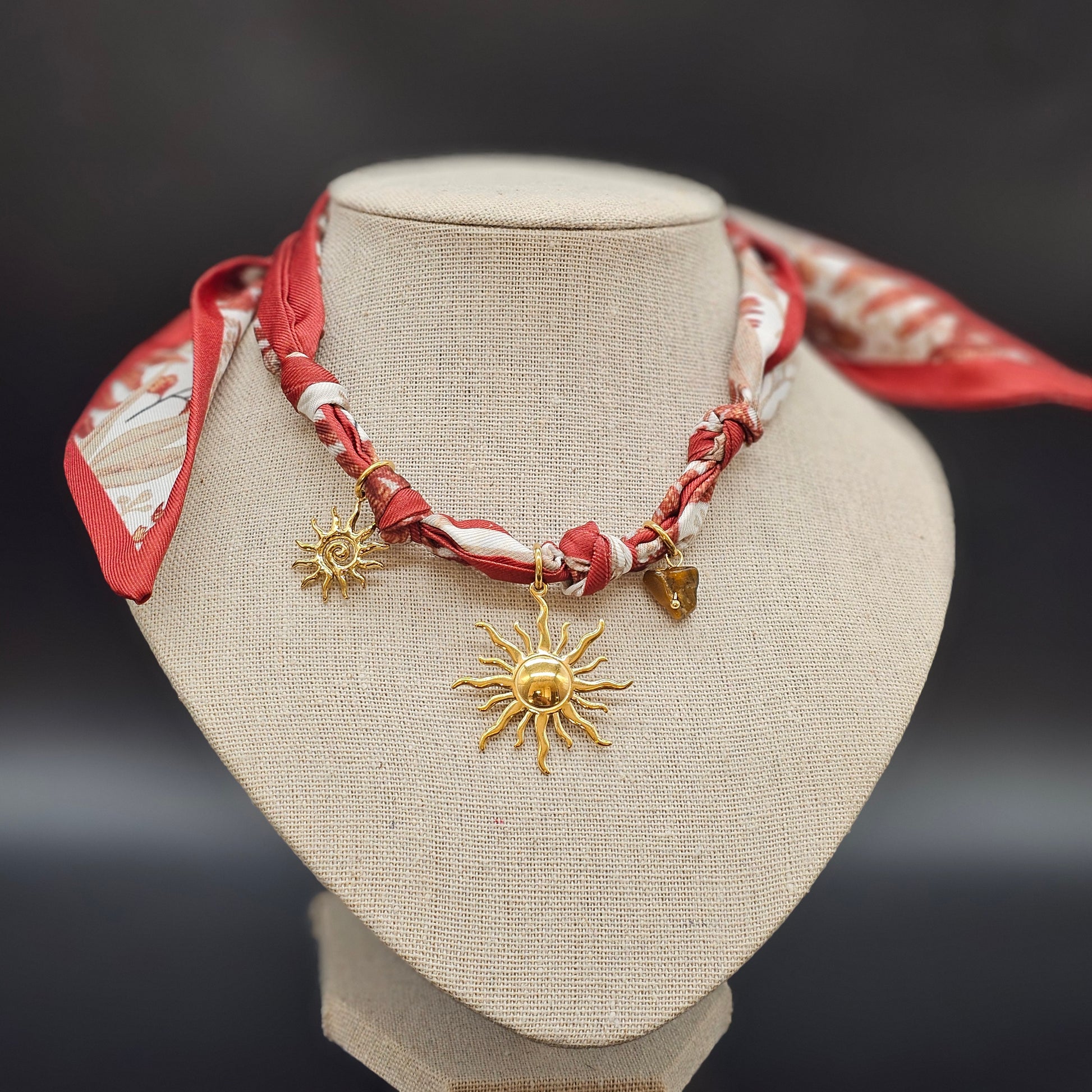 Vue ¾ droite, foulard visible, relief et texture du pendentif.