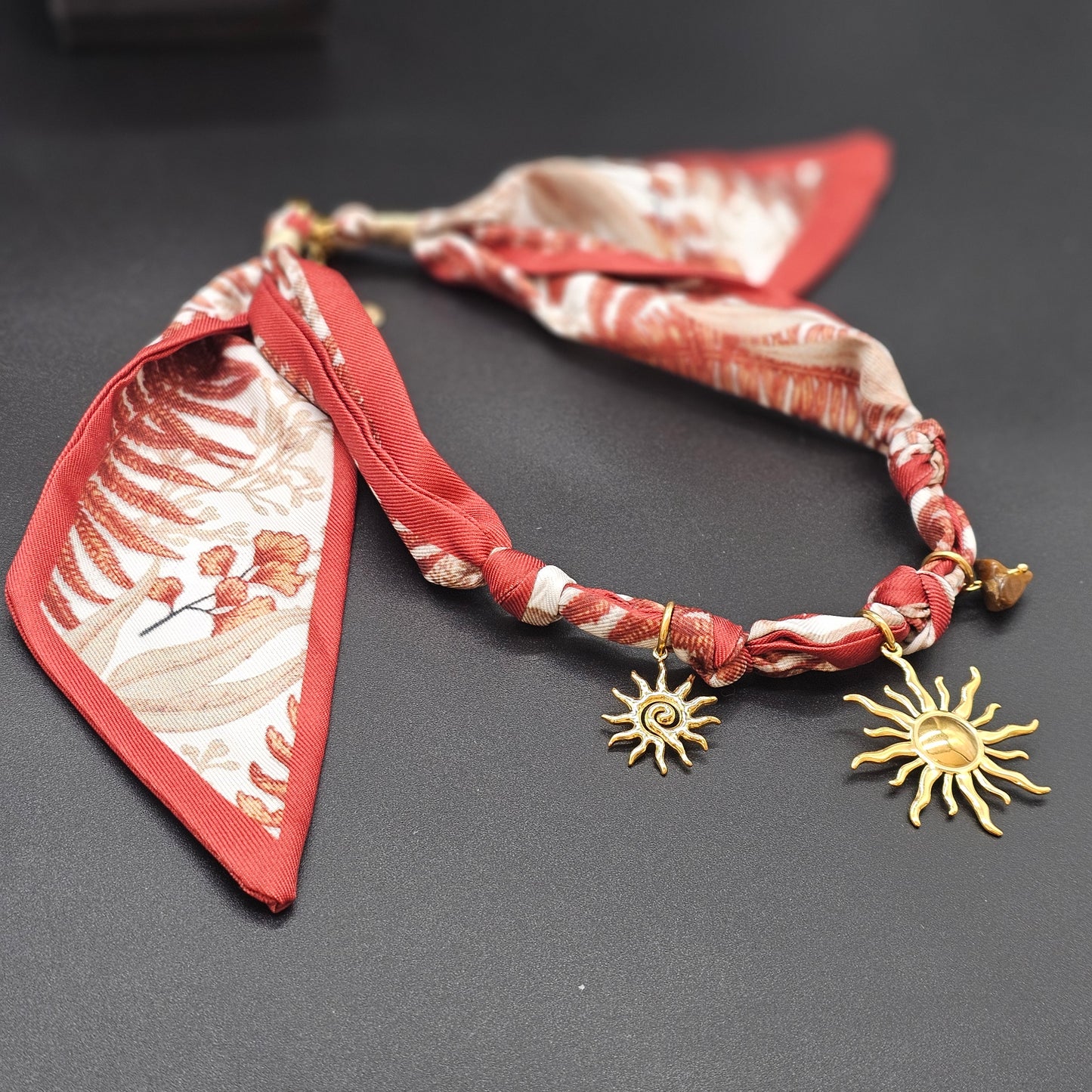 Vue latérale rapprochée, fond sombre, bijou détaillé.