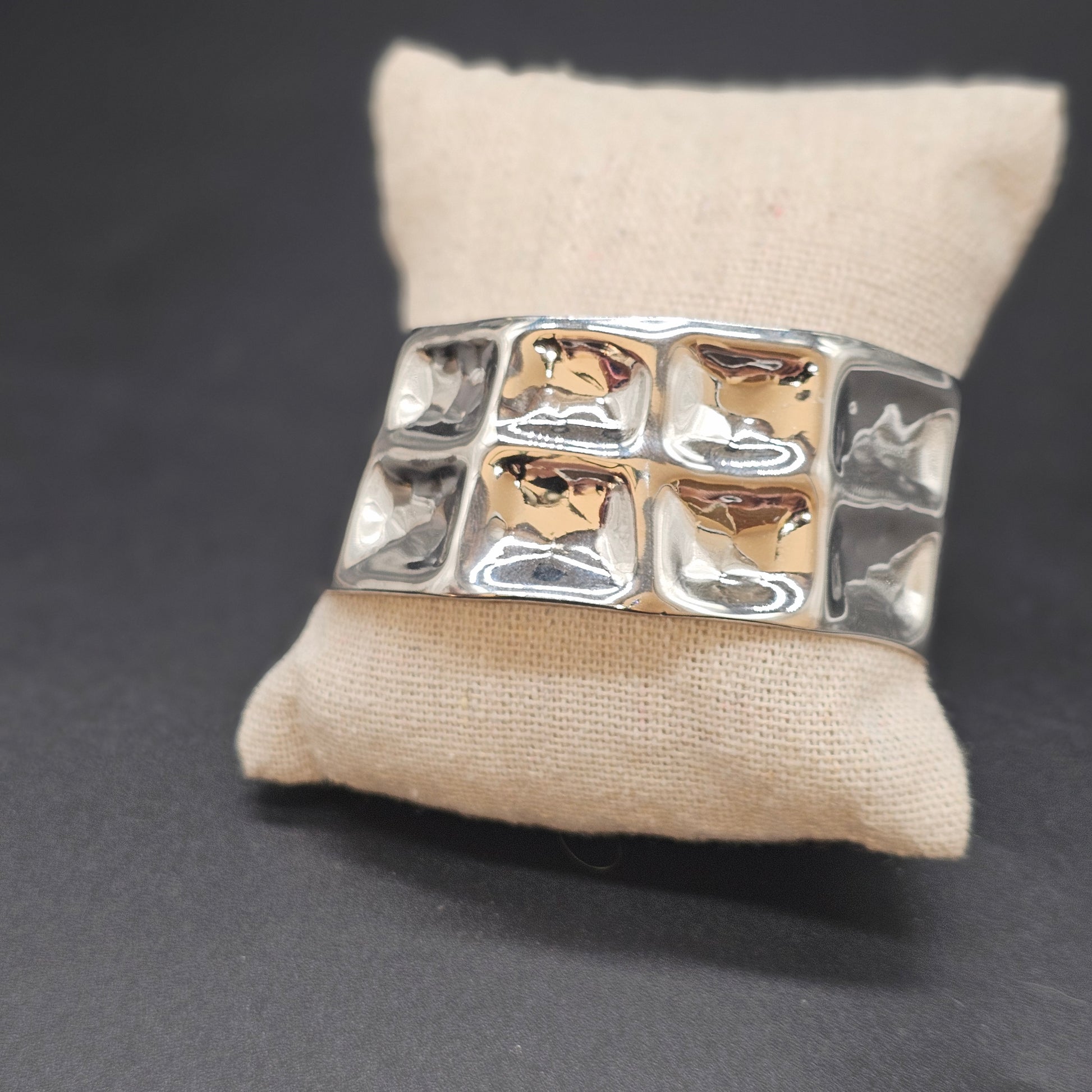 Bracelet manchette cubique argenté en acier inoxydable brillant sur coussin beige – Bijoux Nice