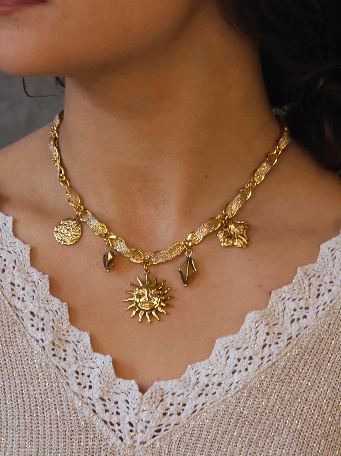 gros plan sur le collier doré pendentif soleil et pampilles dur modele