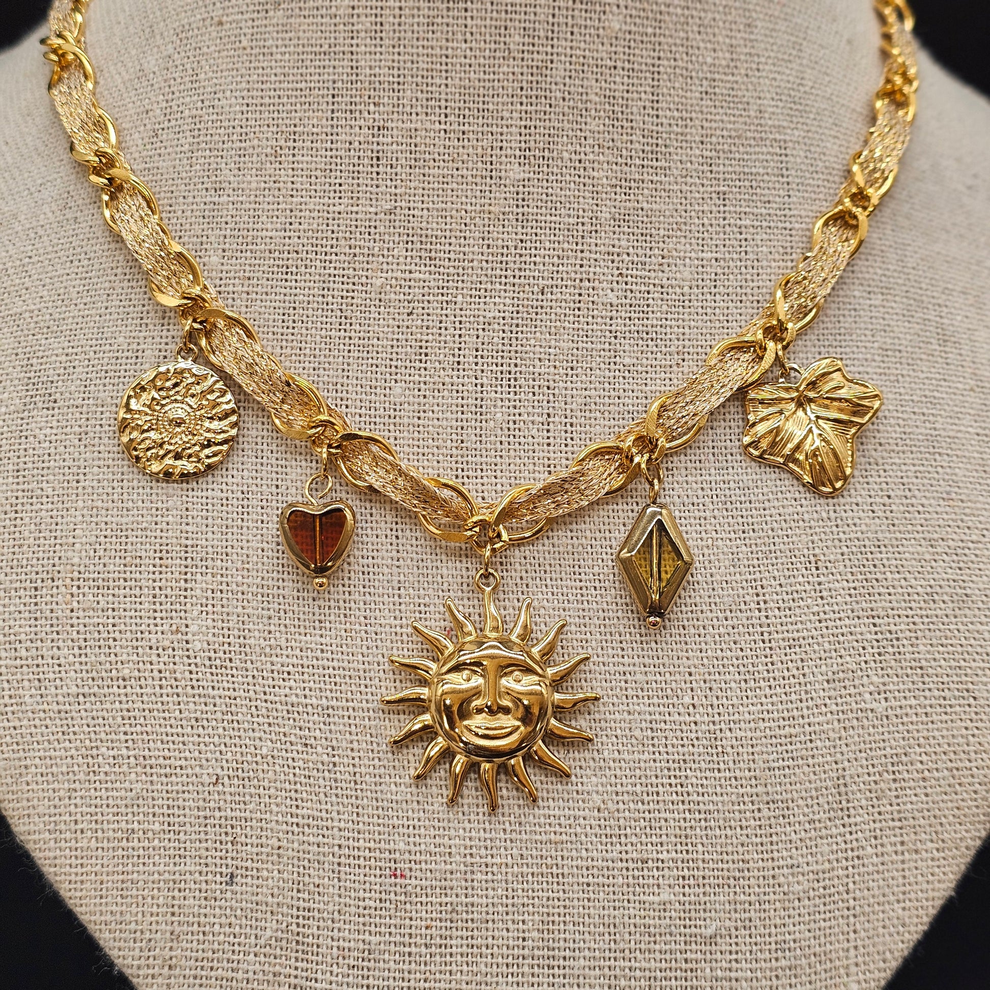 Détail rapproché du collier doré, texture du métal et reflets brillants.