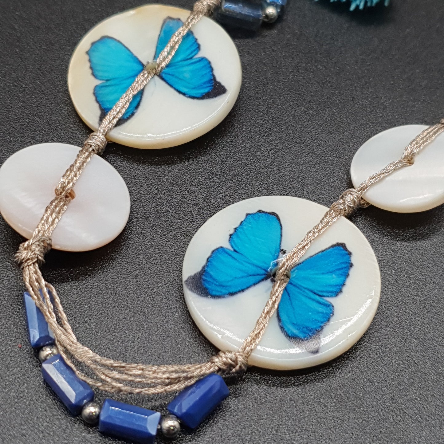 Collier sautoir multi-fils bleu – Nacre, papillon argenté & pompons