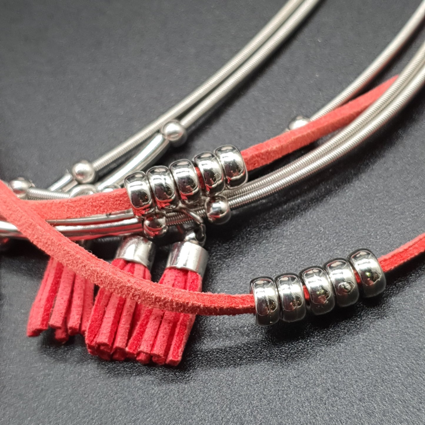 Red multi-strand magnetic necklace with memory wire, silver-plated metal beads, and faux suede