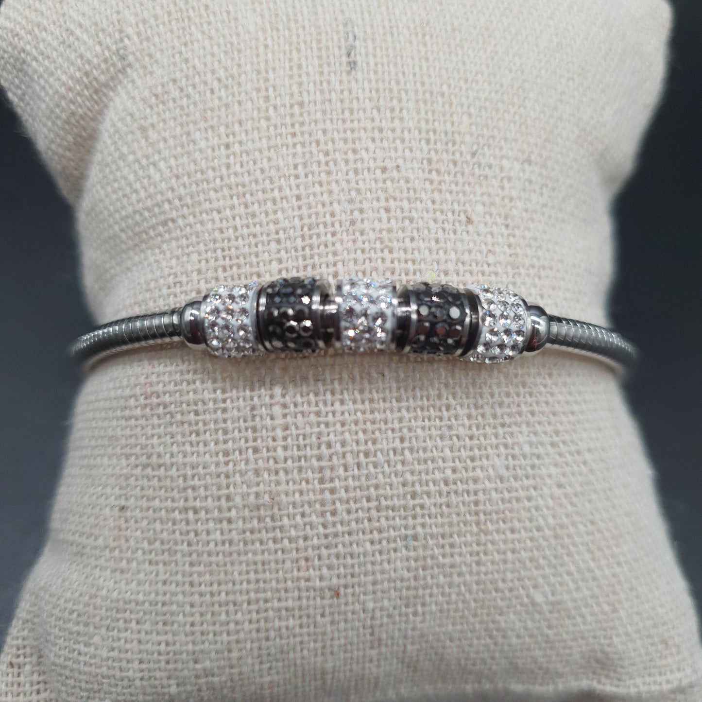 Silver-plated omega mesh magnetic bracelet with metal tubes, white rhinestones, and black crystal shards