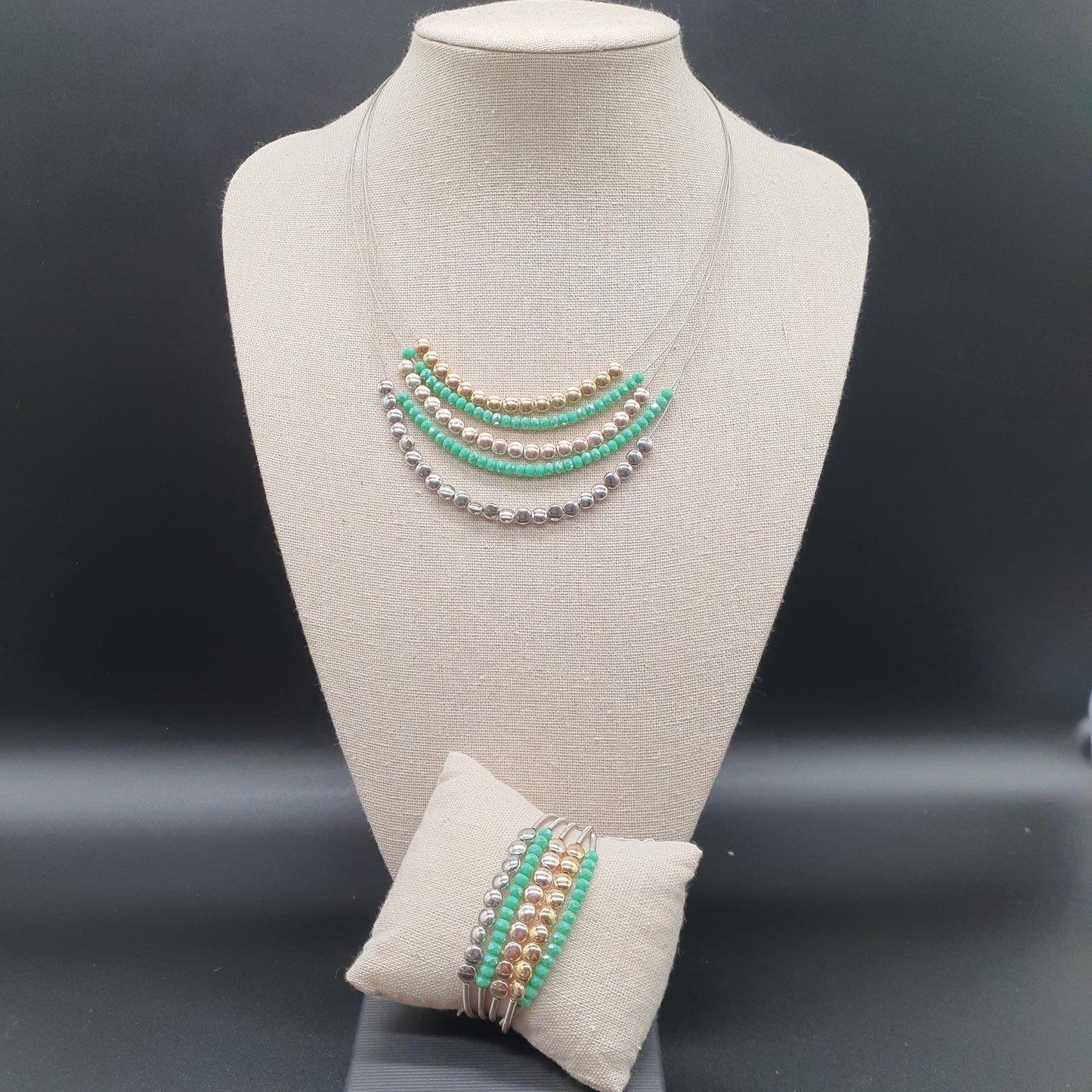 Multistrand magnetic necklace and bracelet set with fine spiraled cables, round silver and gold-tone metal pieces, and colorful crystal