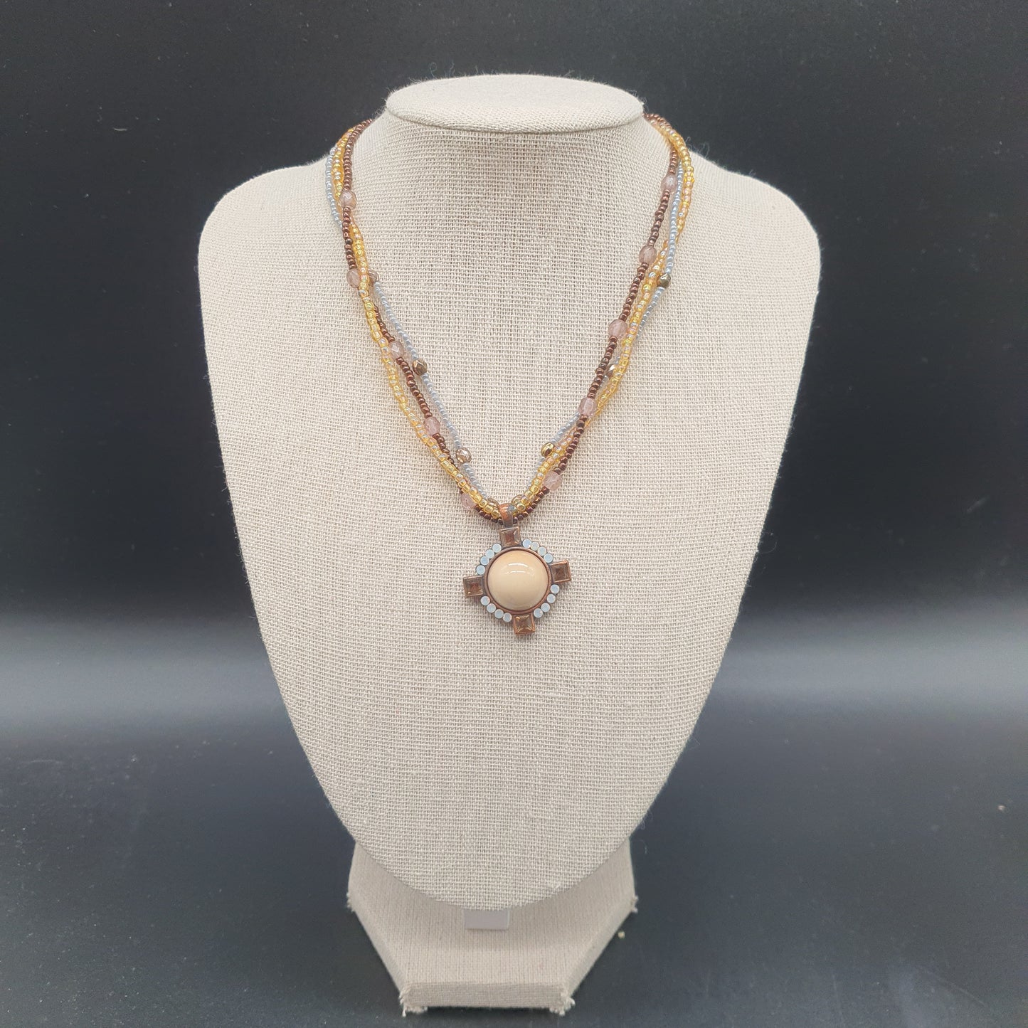 Triple strand gold necklace with faceted beads, enamel medallion & crystal rhinestones
