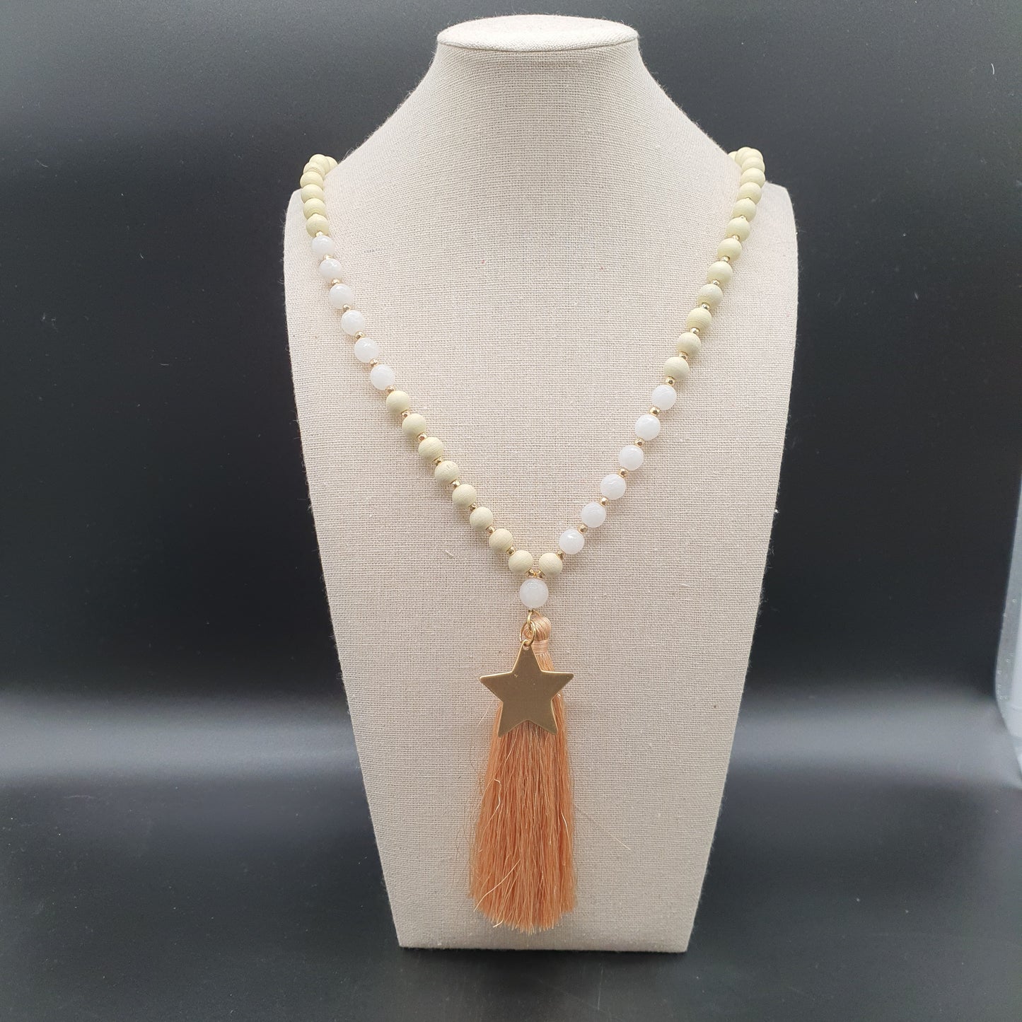 Long necklace with wooden beads, golden star, and tassel