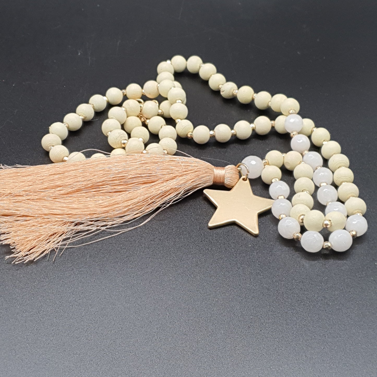 Long necklace with wooden beads, golden star, and tassel